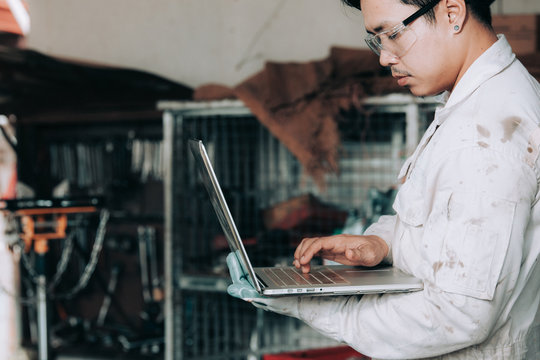 Car mechanic using laptop in auto repair service