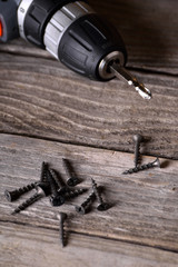 Close up Electric drill on wooden table background and copy space.  Hammer drill or screwdriver, Electric cordless hand drill on wooden. maintenance home concept. Screwdriver on a wooden background wi