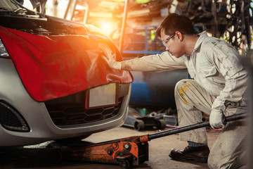 Mechanic with Floor Jack Car Lift. Vehicle Maintenance in the Auto Service Center.