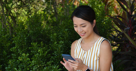 Woman use of mobile phone with the green background