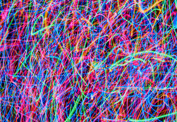 Abstract colored light lines on a black background. Blue, green, orange, pink lines and curves.