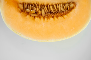Fresh sweet orange melon on the white plate as a background with a selective focusing. Useful and vitamin-rich food. Vegeterian.