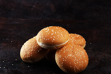 Fresh homemade burger buns with sesame on dark background