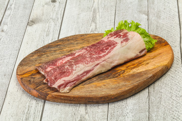 Raw beef bacon over wooden board