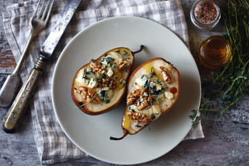 Selective focus. Baked pears with dor blue cheese on a plate. Healthy lunch. Keto diet. Keto snack.