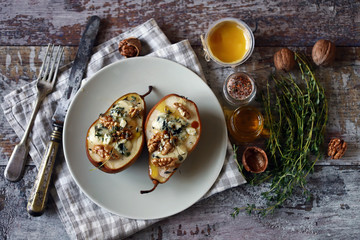 Selective focus. Baked pears with dor blue cheese on a plate. Healthy lunch. Keto diet. Keto snack.
