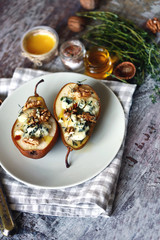 Selective focus. Baked pears with dor blue cheese on a plate. Healthy lunch. Keto diet. Keto snack.
