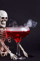 Halloween bloody cocktail with skeleton