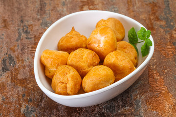 Sweet tasty profiteroles heap in the bowl