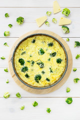 Broccoli tarte with cheese and cottage cheese on a wooden table.