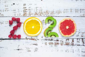 New year 2020 made of fruit and berries on white wooden background.