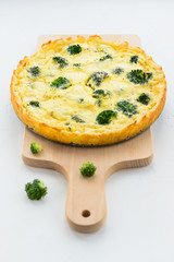Homemade tart with broccoli and cheese on a white background.