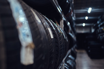 Dark storage full or big variety of new tyres at busy warehouse.