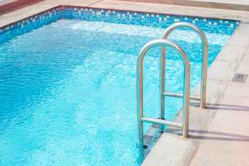 Metal staircase for the pool. Hotel swimming pool. Copy space