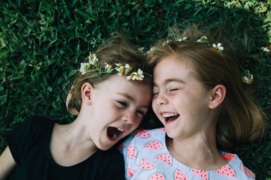 Close up of laughing siblings laying on grass