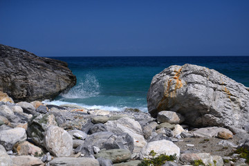 Scenic water splash at coast and a rock in ocean