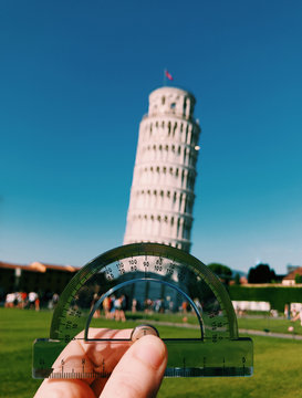 Man Using a Protractor to measure the angle of the Leaning Tower of Pisa Italy . Concept