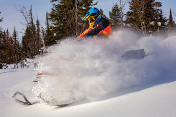 In deep snowdrift snowmobile rider make fast turn. Riding with fun in deep snow powder during backcountry tour. Extreme sport adventure, outdoor activity during winter holiday on ski mountain resort