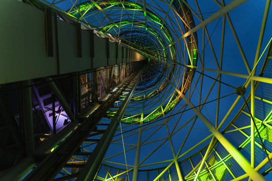 abstract metal tower design with green neon light bottom view