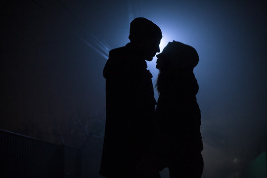 silhouette of a couple in love at night on the background of the moon