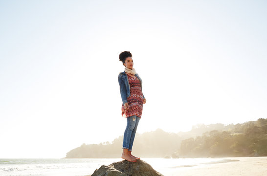 Portrait of mixed race woman standing on a rock at the beach