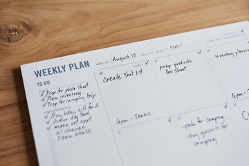 Overhead shot of a weekly planner on a wooden desk