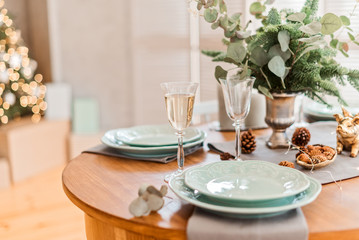 Festive christmas table with plate and glasses with champagne