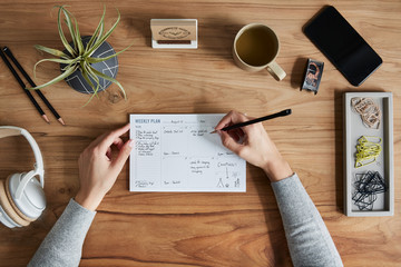 Overhead shot of a small business owner writing in weekly planner