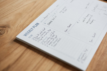 Overhead shot of a weekly planner on a wooden desk