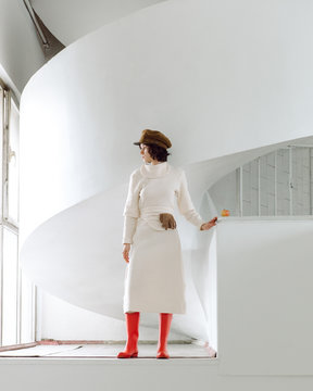 Elegant woman in gumboots standing white hall