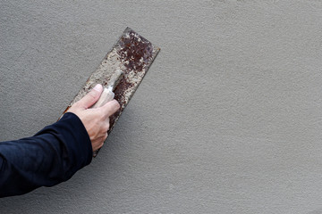 Concrete wall background, Hand using steel trowel to finish Plaster wall