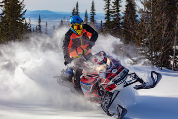 In deep snowdrift snowmobile rider make fast turn. Riding with fun in deep snow powder during...