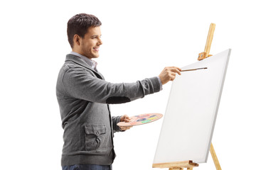 Young man painting on a canvas