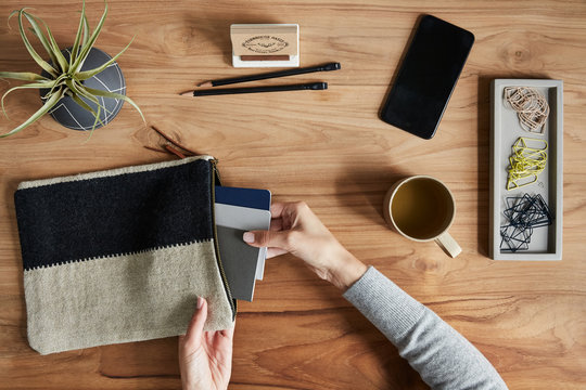 Overhead shot of a small business owner placing notepads in a canvas bag - Powered by Adobe