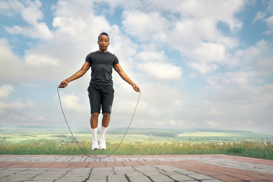 Man exercising with jump rope outdoors