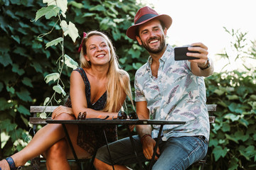 Couple taking a selfie on a terrace in sunset