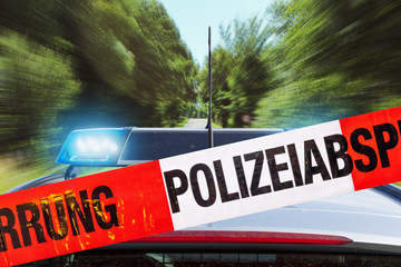 Obraz premium Polizeiabsperrung mit Polizeiwagen im Hintergrund