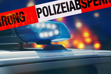 Polizeiabsperrung mit Polizeiauto im Hintergrund