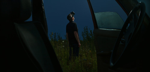 Man using vr glasses in field at night