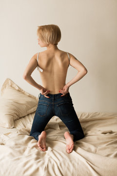 Happy Young Woman Taking Off Her Jeans