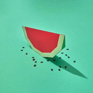 Handcraft paper slice of juicy watermelon with seeds on a green