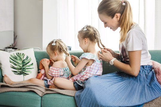 Mother braiding her daughters