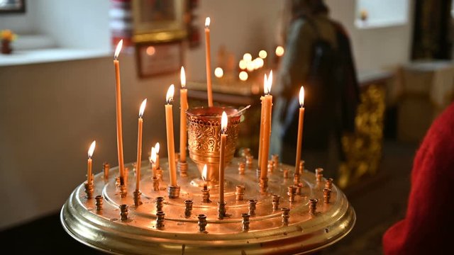 burning candles on a candlestick at the empty orthodox church