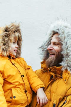 Father and kid wearing yellow hooded coat.