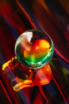 Crystal ball laying on holographic colorful background