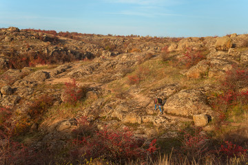 Obraz premium Bactive, active rest, activity, adult, adventure, autumn, background, backpack, bearded man, canyon, clack of an old male tourist with a gray beard against the backdrop of mountains, rocks and forests