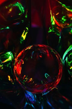 Abstract shot of glass ball on colorful holographic backdrop