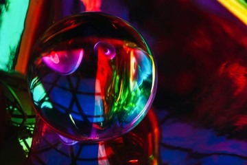Abstract shot of glass ball on colorful holographic backdrop