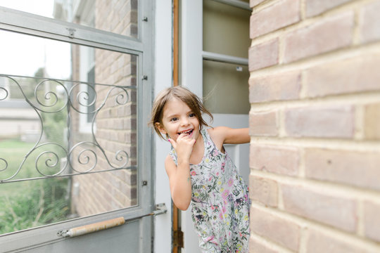 little girl looks out door