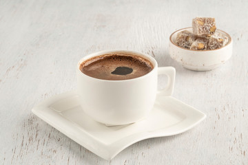 A cup of Turkish coffee and delight on a wooden table